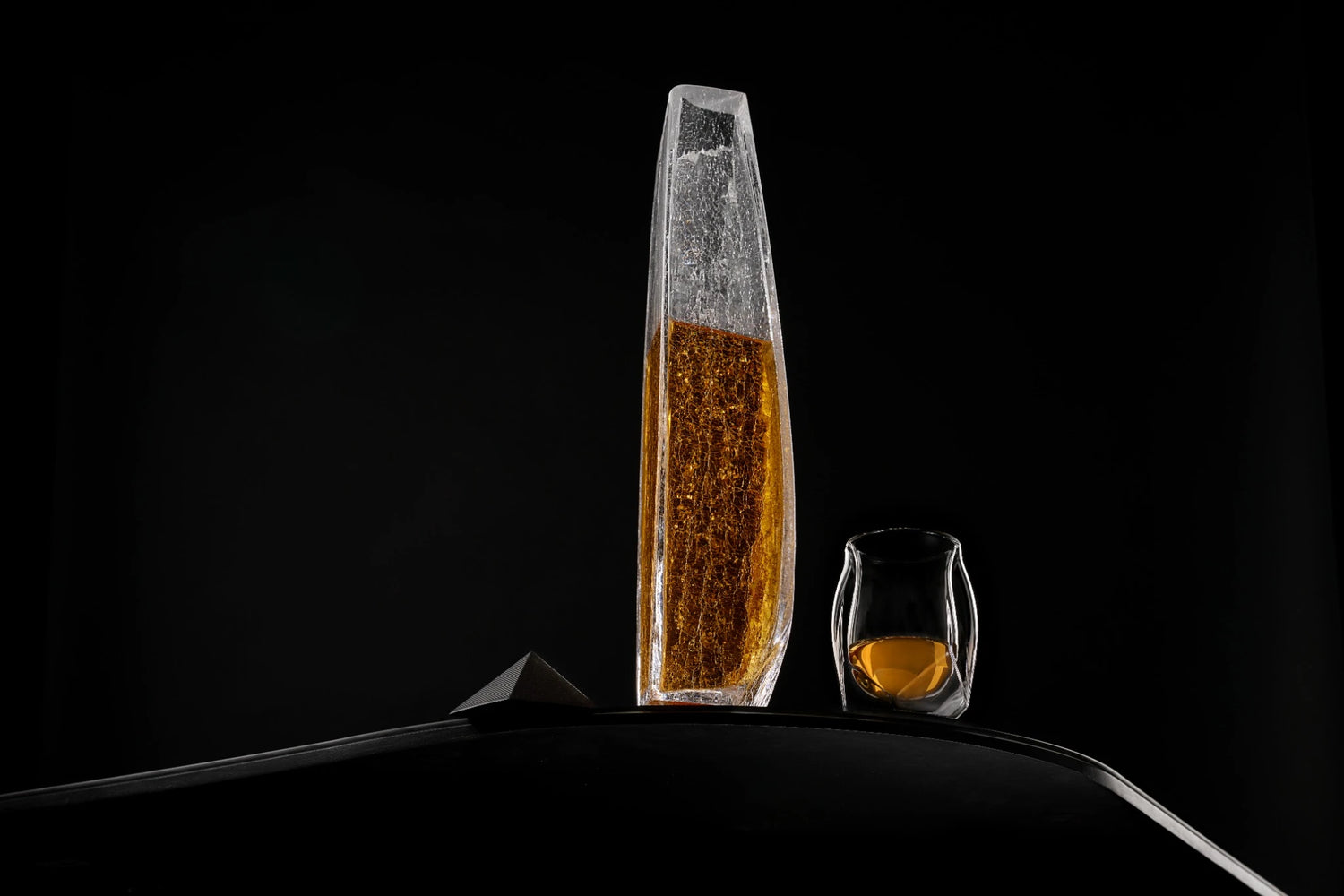 A panoramic shot of the Raif Whisky Decanter - Crackle Edition with whisky shot next to the Norlan Whisky Glass (Clear). A perfect pairing.