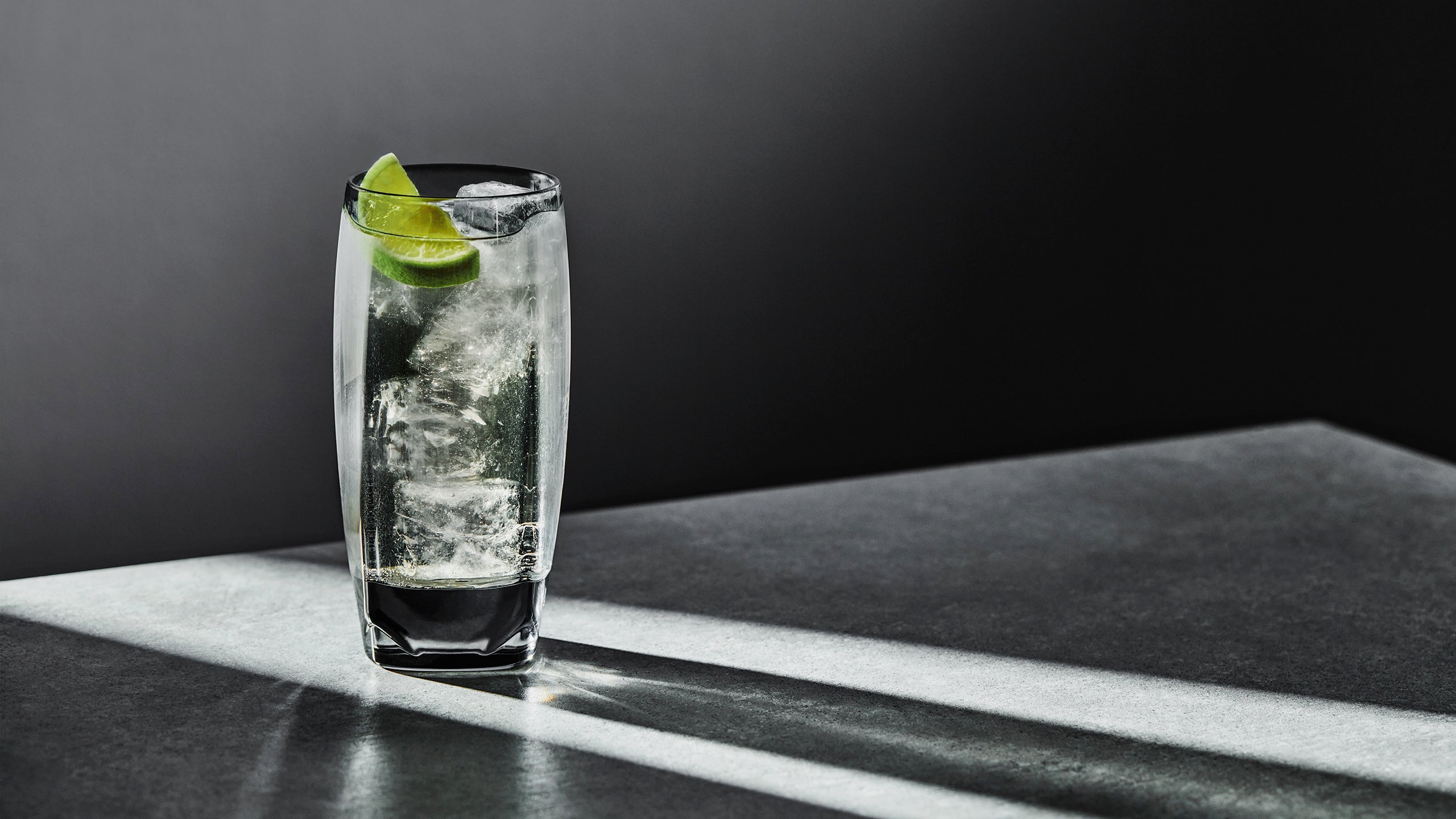 A full highball glass, namely our grey Vawe, with a spicy whisky ginger and lime cocktail. 
