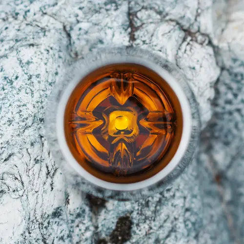 Aerial view of whisky in Norlan tumbler on light grey slate rocks