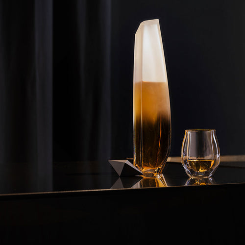 The Raif Whisky Decanter in gradient clear standing beside the Norlan Whisky Glass