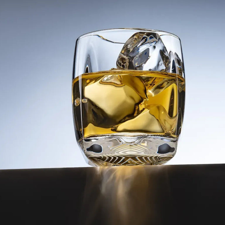 A lifestyle image of the Rauk Heavy Tumbler 250 mL (Clear) sitting on a black ledge against a light blue background. 