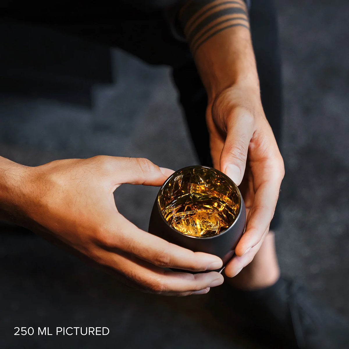 Detail of the interior of the single old fashioned Rauk Heavy Tumbler with mirrored surface reflecting the whiskey inside. 